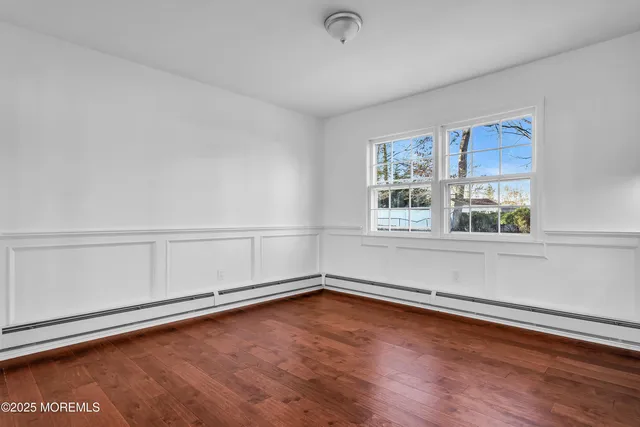 a kitchen with stainless steel appliances white cabinets granite counter tops and a hard wood floors