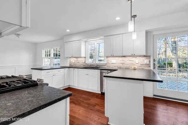 a kitchen with stainless steel appliances granite countertop a refrigerator and a stove top oven