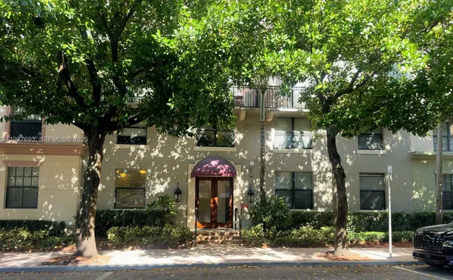a front view of a house with a yard and tree s