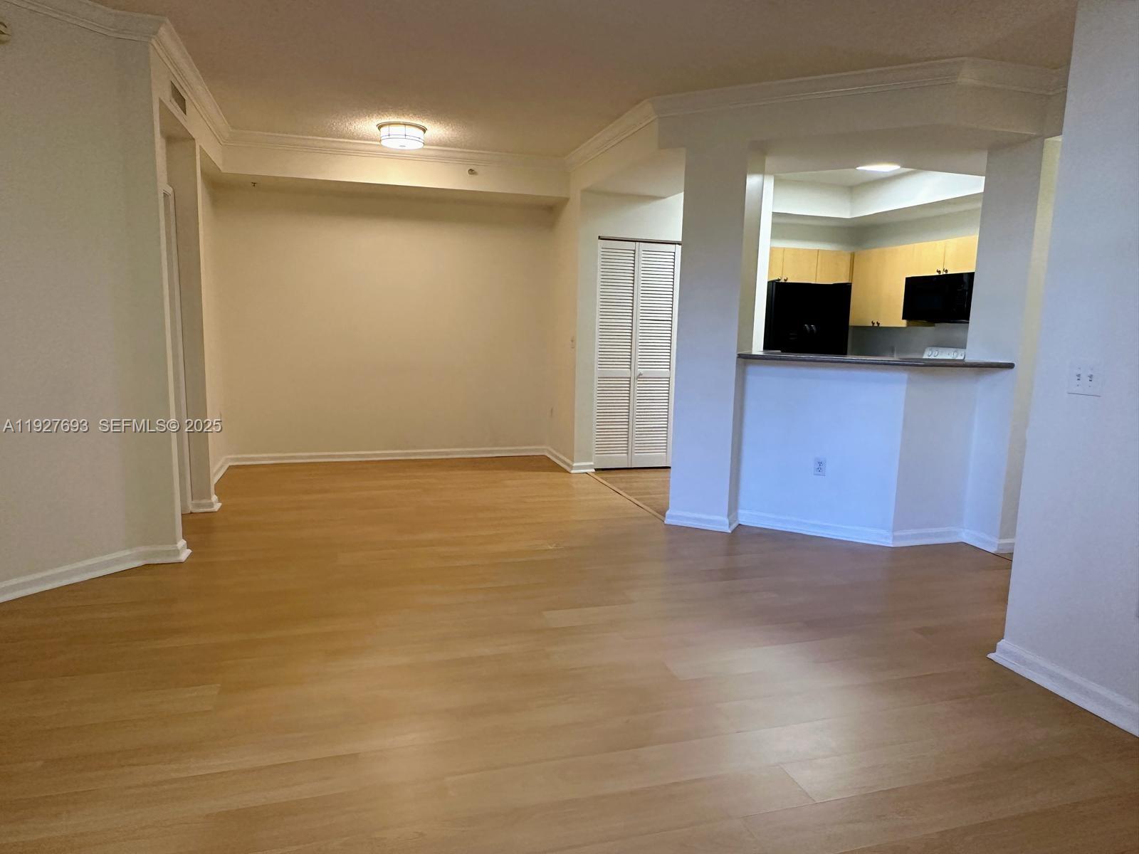 1919 Van Buren Street, Unit 118A Hollywood, FL 33020 - Photo 13 of 36 a view of a hallway with wooden floor and a flat screen tv