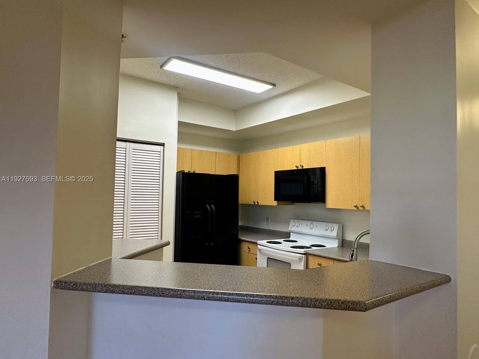 1919 Van Buren Street, Unit 118A Hollywood, FL 33020 - Photo 20 of 36 a kitchen with a sink and a refrigerator