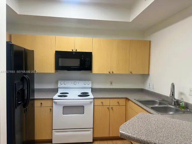 a kitchen with a sink stove and refrigerator