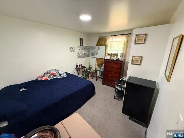 a bedroom with a bed dresser and a window