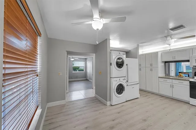 a view of a kitchen with a sink and dishwasher white cabinets with wooden floor