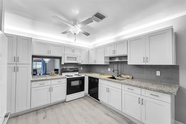 a kitchen with white cabinets stainless steel appliances and sink