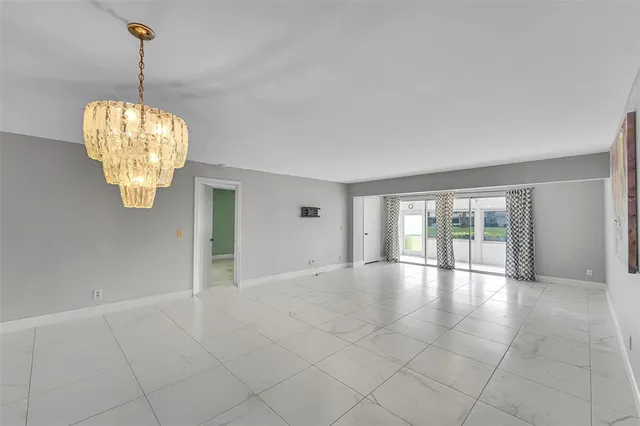 an empty room with windows and chandelier