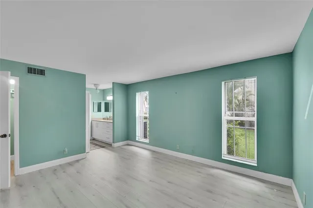 an empty room with closet and windows