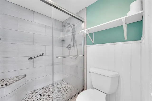 a white toilet sitting next to a bathroom