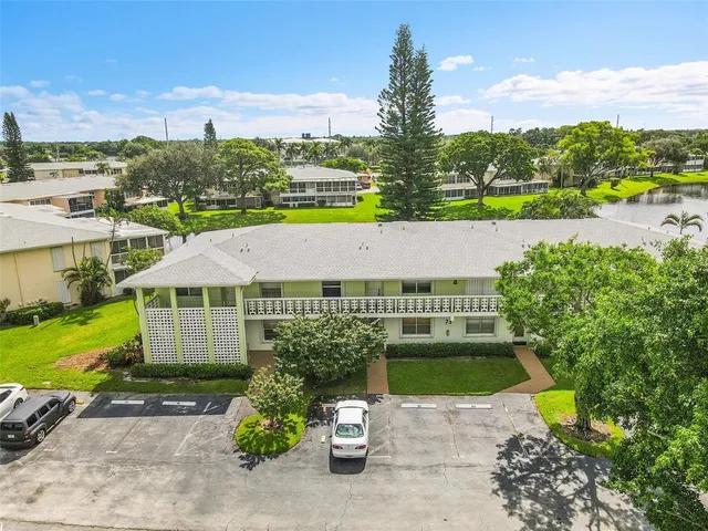 an aerial view of a house with a garden and lake view