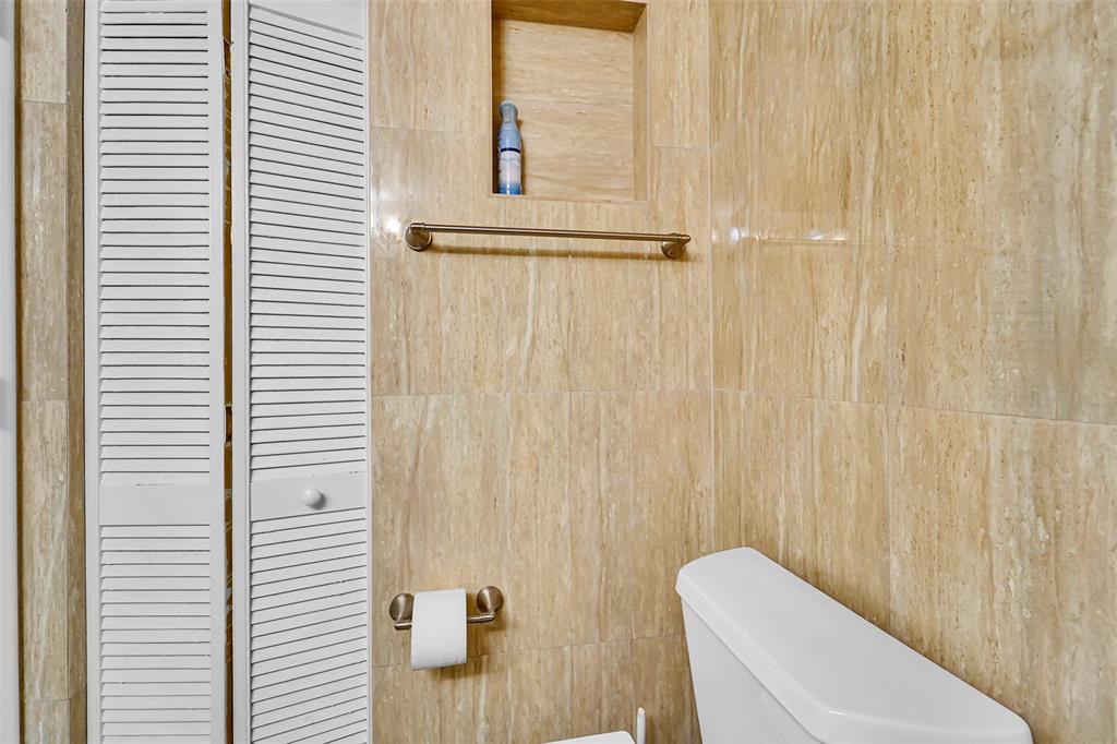 1521 Northwest 19th Terrace, Unit 101 Delray Beach, FL 33445 - Photo 10 of 42 a bathroom with a toilet and a shower curtain