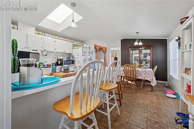 16830 Finch Road Colorado Springs, CO 80928 - Photo 29 of 49 Mobile home kitchen with skylight, breakfast bar, and dining area