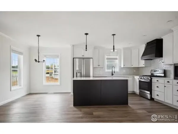 a kitchen with stainless steel appliances granite countertop a sink dishwasher a stove and a wooden floor