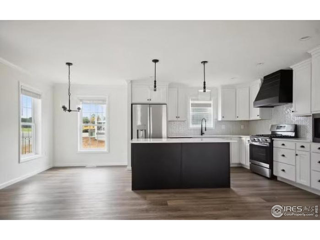 505 Carson Street Brush, CO 80723 - Photo 3 of 7 a kitchen with stainless steel appliances granite countertop a sink dishwasher a stove and a wooden floor