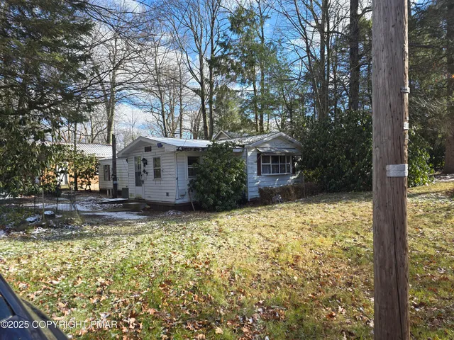 a front view of a house with a yard garage and tree