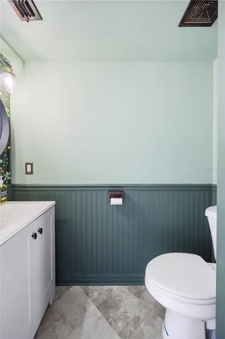 a bathroom with a toilet a sink and mirror