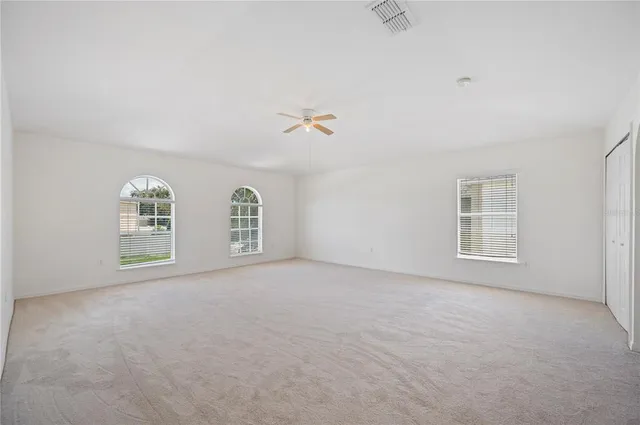 an empty room with windows and bathroom