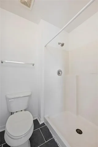 a white toilet sitting next to a bath tub