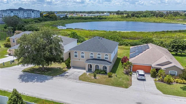 an aerial view of a house with a garden and lake view