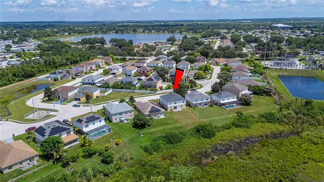 an aerial view of a house with a garden and lake view