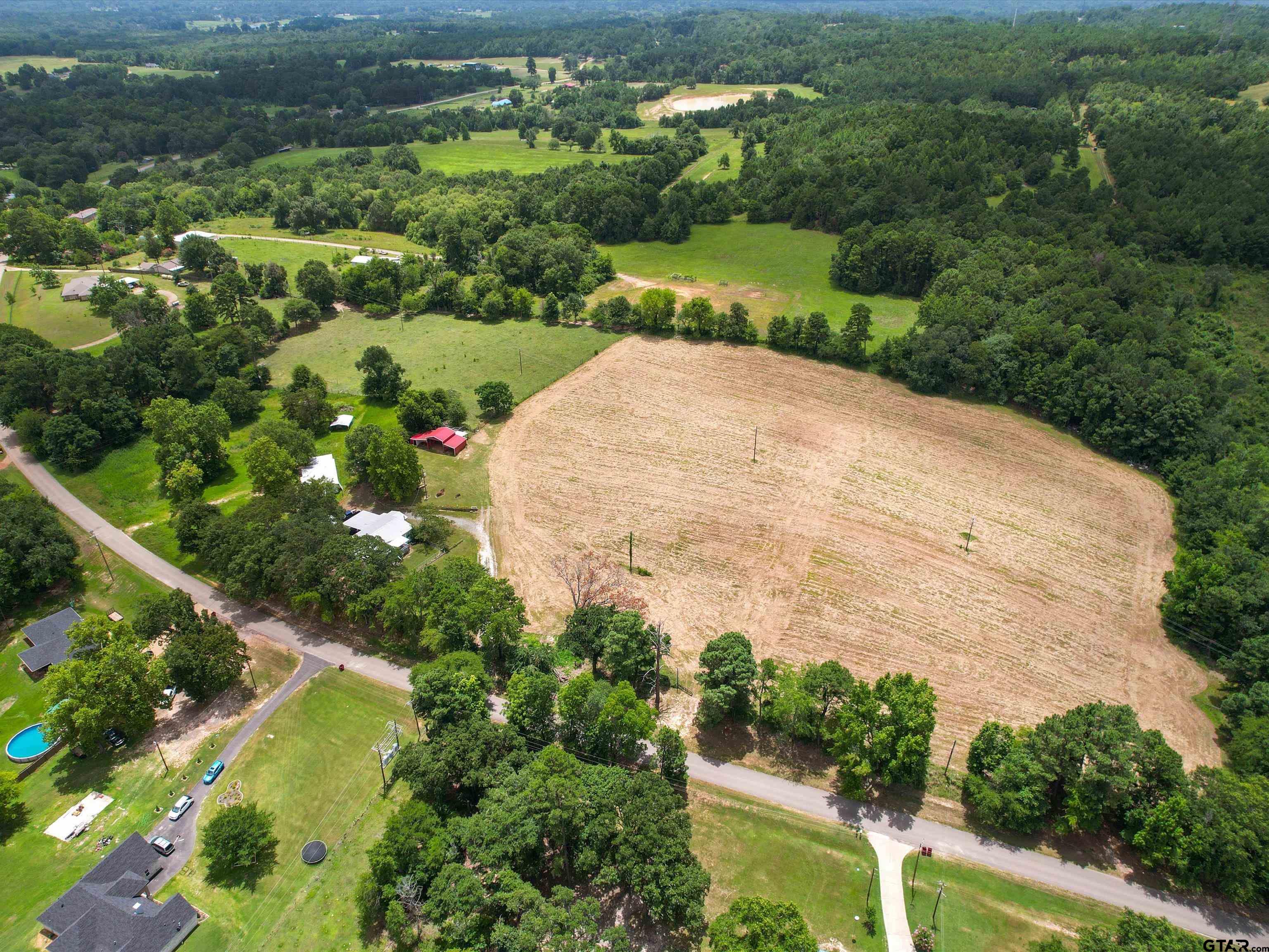 2811 Medlin Road Gilmer, TX 75645 - Photo 2 of 30 a view of a garden with a building in the background
