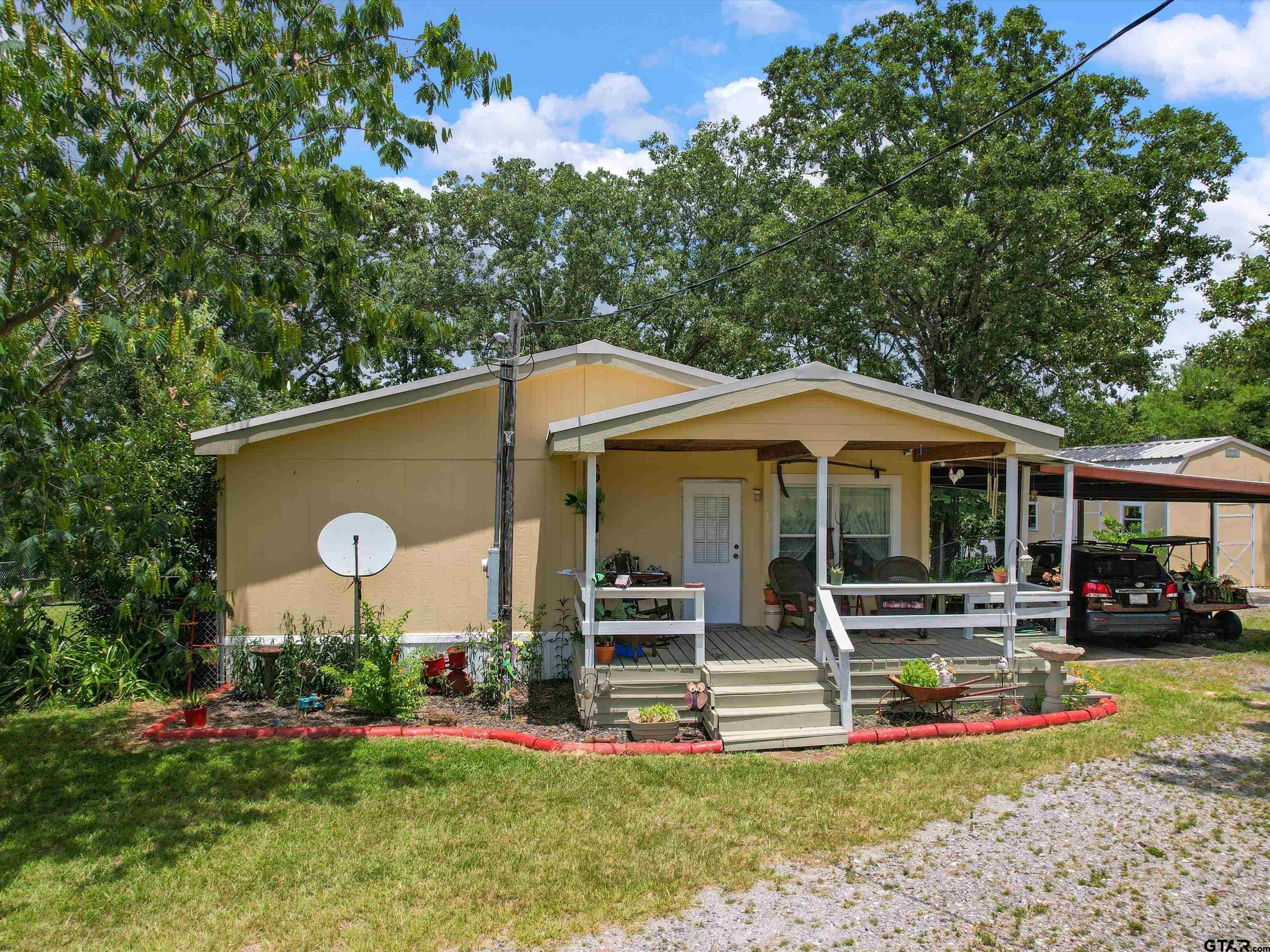 2811 Medlin Road Gilmer, TX 75645 - Photo 7 of 30 a front view of a house with a yard table and chairs