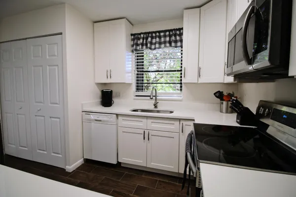 a kitchen with stainless steel appliances a sink stove and cabinets