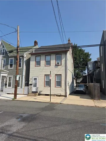 a front view of a house with a road