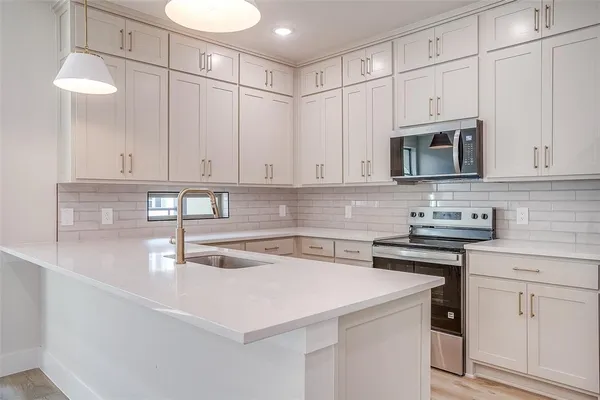 a kitchen with stainless steel appliances granite countertop a sink a stove and a microwave