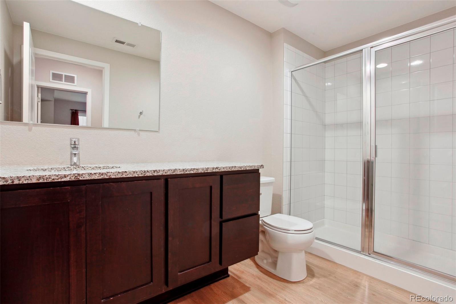 6735 Avrum Drive Denver, CO 80221 - Photo 26 of 29 a bathroom with a granite countertop sink toilet and mirror