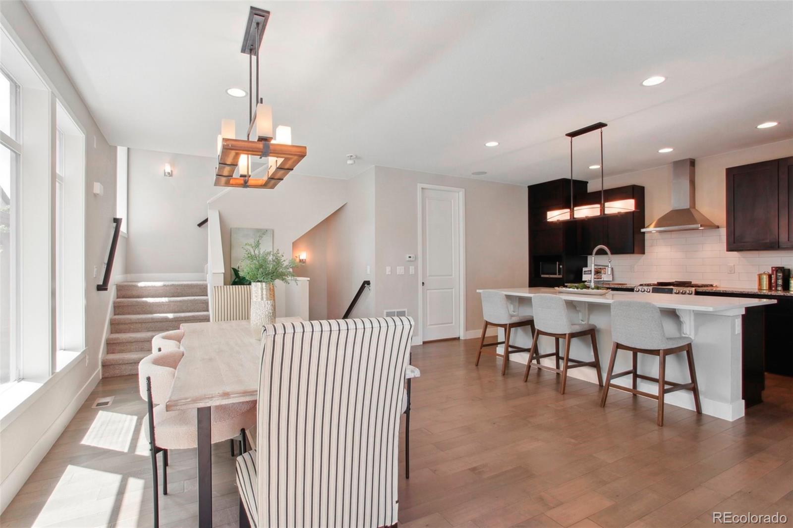 6735 Avrum Drive Denver, CO 80221 - Photo 5 of 29 a view of dining room and livingroom with furniture wooden floor a chandelier