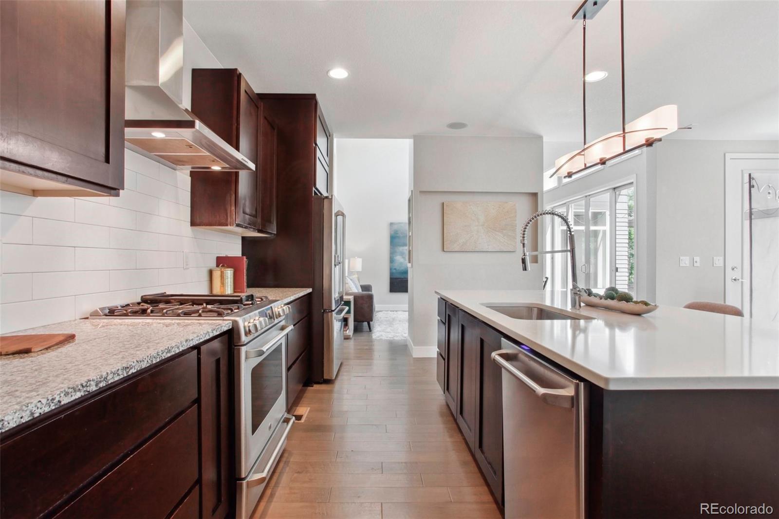 6735 Avrum Drive Denver, CO 80221 - Photo 9 of 29 a kitchen with stainless steel appliances granite countertop a sink a stove and a refrigerator