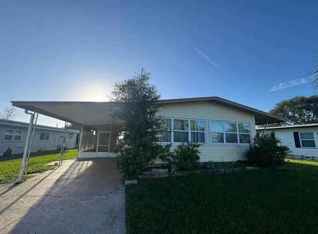 a front view of a house with a yard and potted plants