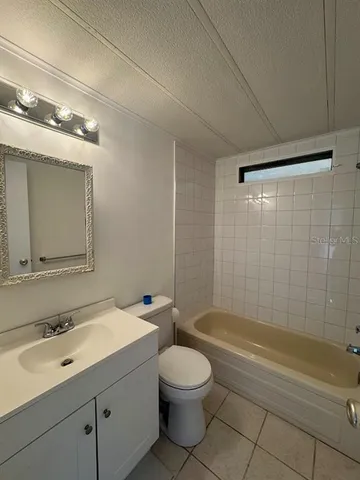a bathroom with a toilet a sink a mirror and a bathtub