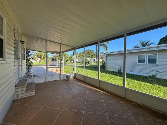 a view of a porch with chairs and backyard