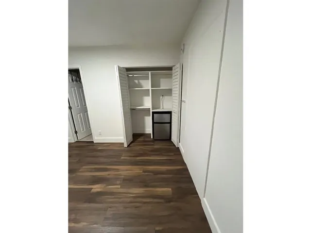 a view of a hallway with wooden floor and a hallway