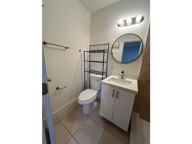 a bathroom with a toilet a sink and a mirror