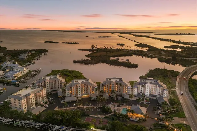 a front view of a building with plants and palm trees