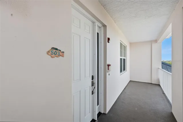 a bedroom with a bed a couch and a flat tv screen on the dresser