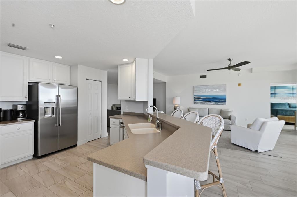 13113 Gasparilla Road, Unit 503 Placida, FL 33946 - Photo 70 of 87 a kitchen with stainless steel appliances granite countertop a refrigerator a stove and a sink with wooden floor