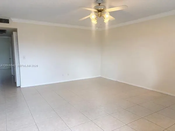 an empty room with a ceiling fan and carpet