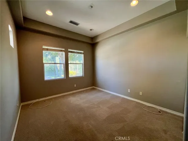 a view of empty room with wooden floor and windows