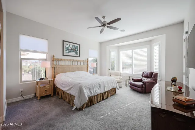 a bedroom with a bed a couch and a flat screen tv