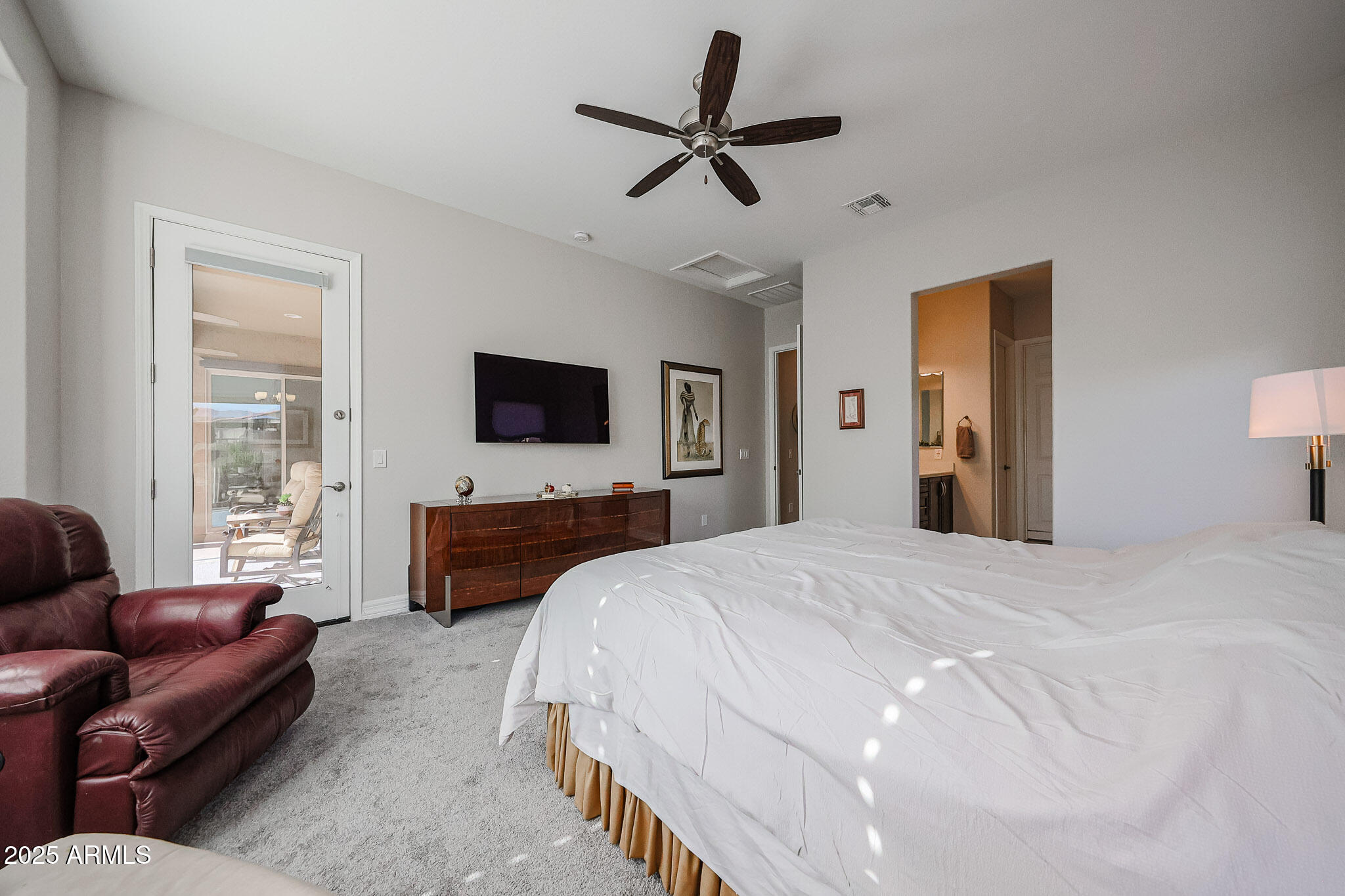 17885 West Ashurst Drive Goodyear, AZ 85338 - Photo 21 of 63 a bedroom with a bed a couch and a flat screen tv