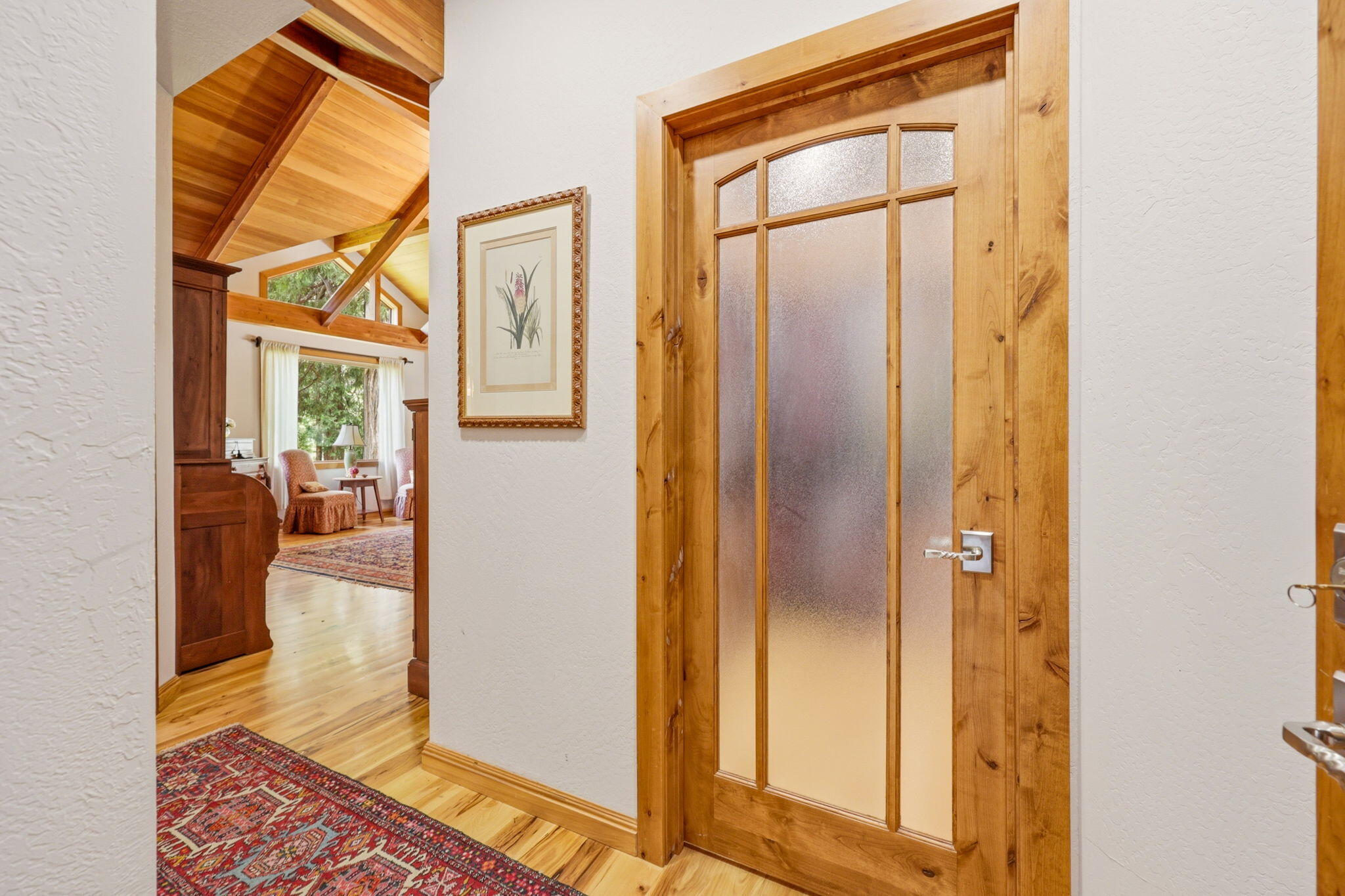 985 Elliott Creek Road Wilderville, OR 97543 - Photo 29 of 98 a view of a hallway with wooden floor and a living room