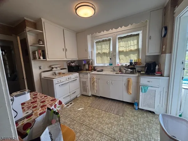 a kitchen with a sink appliances cabinets and a window