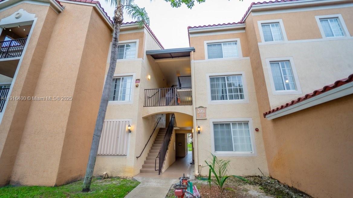 a view of a house with many windows and a yard