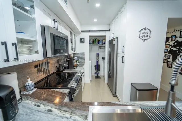 a kitchen with stainless steel appliances granite countertop a refrigerator and a stove