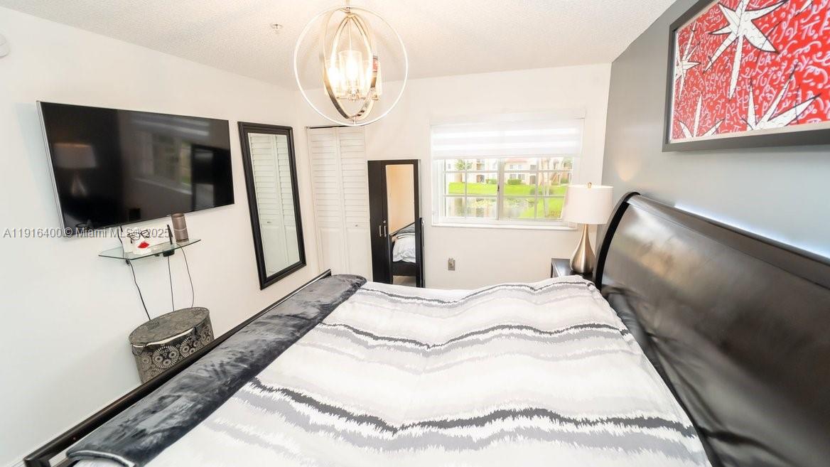 The Enclave at Miramar Miramar, FL 33025 - Photo 22 of 23 a spacious bedroom with a bed and a flat screen tv