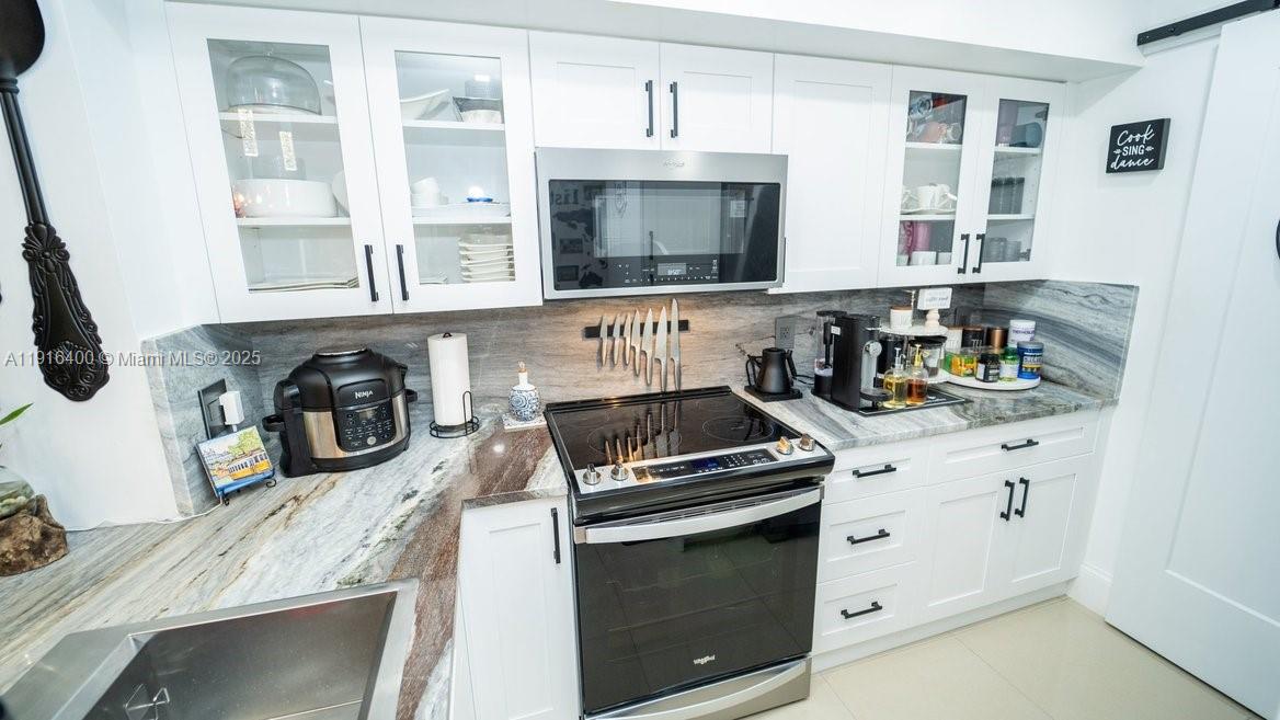The Enclave at Miramar Miramar, FL 33025 - Photo 7 of 23 a kitchen with granite countertop a stove and a sink