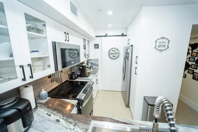 a kitchen with granite countertop a refrigerator and a stove